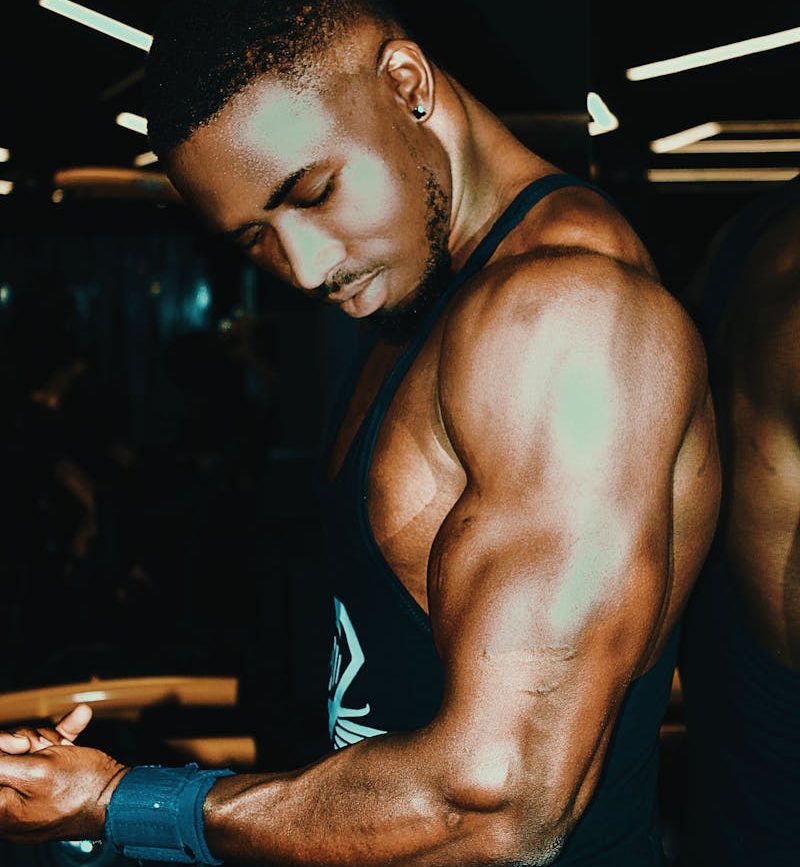 Man in Tank Top Holding Dumbbell